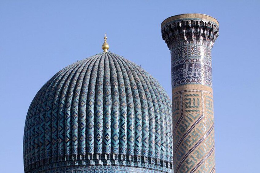 Una struttura a cupola con decorazioni elaborate e un'alta colonna slanciata con sculture dettagliate. 3