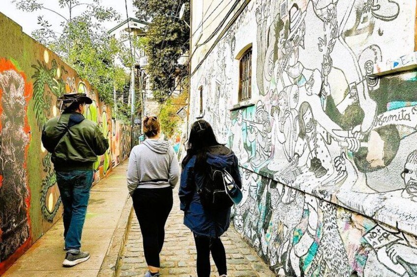 A narrow alley with graffiti-covered walls and a cobblestone path. 3