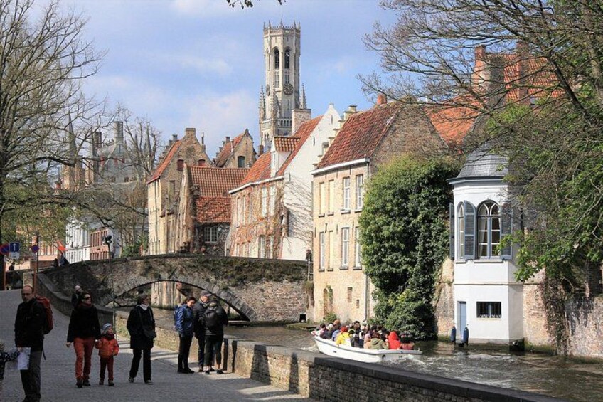 A canal with a boat, historic buildings, and a bridge. 3