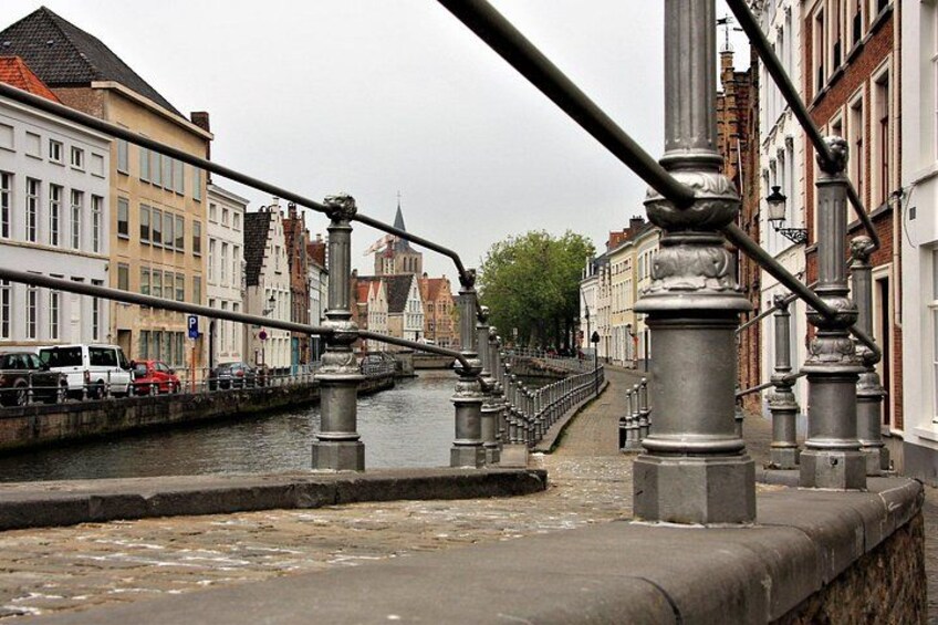 A canal with a bridge, buildings, and a tree. 2