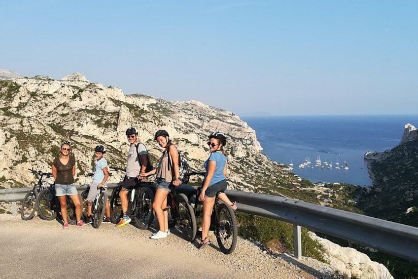 A group of people on a coastal road with rocky cliffs and the sea in the background. 4