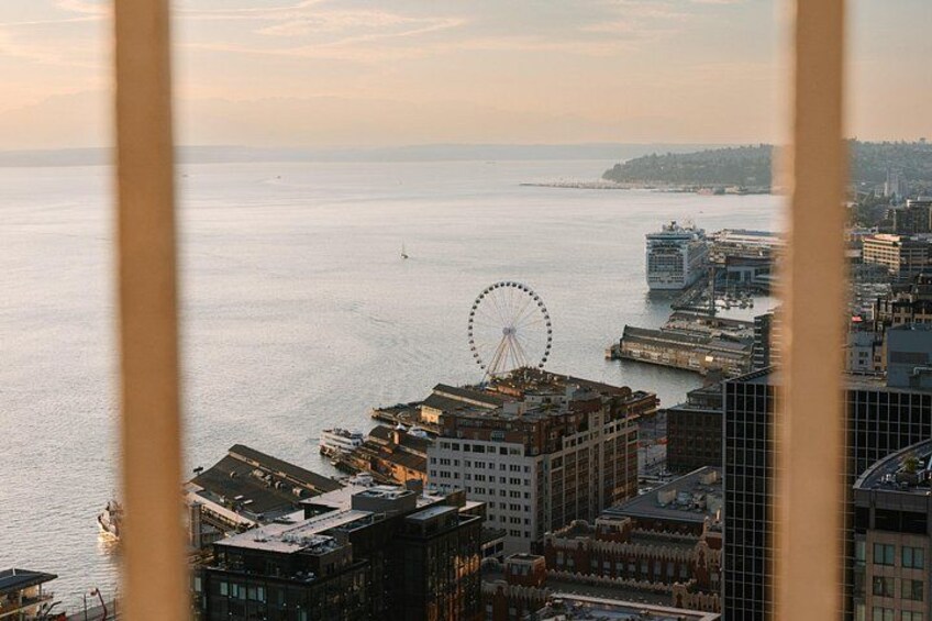 Un paysage urbain côtier avec une grande roue bien visible, des bâtiments et une étendue d’eau. 3