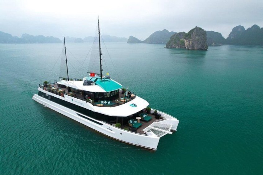 Un yate blanco grande con techo verde navegando sobre aguas turquesa. 1