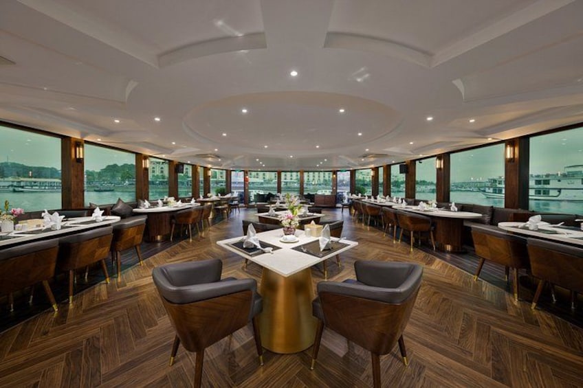 Un restaurante amplio con vistas a un río y edificios. 4