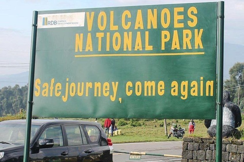 A sign for Volcanoes National Park with a message 'Safe journey, come again'. 3