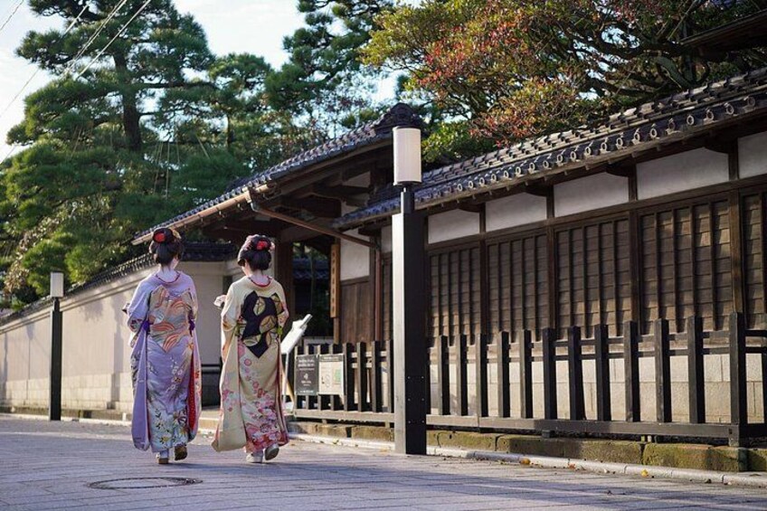 Zwei Frauen in traditionellen japanischen Kimonos gehen auf einer Straße. 2