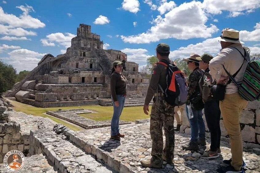 Un groupe de personnes se tient sur des ruines antiques, avec une grande pyramide en arrière-plan. 2