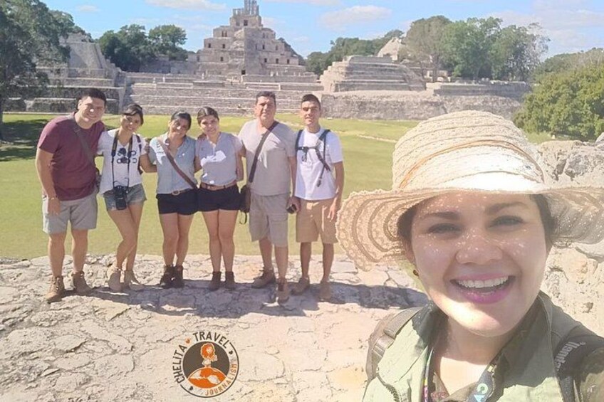 A group of people standing in front of ancient ruins with a large stone structure in the background. 2