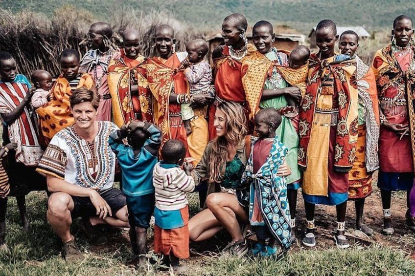A group of people in traditional attire, some children, and a person in casual clothing. 3
