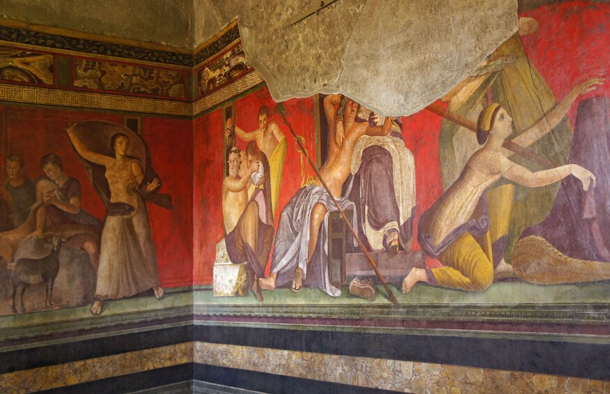 Een fresco muurschildering met figuren in klassieke kleding, een stenen vloer en een gedeeltelijk zichtbaar plafond. 2