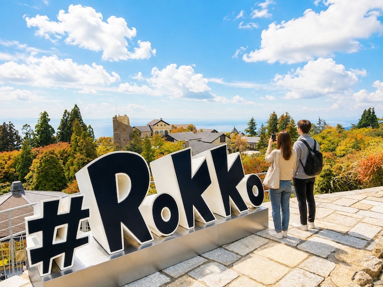 Ett par tar ett foto med en skylt med texten ”Rokko” i bakgrunden. 4