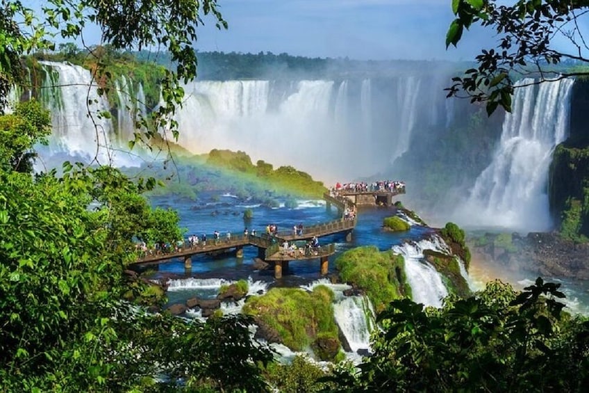 A large waterfall with a viewing platform and a rainbow. 1