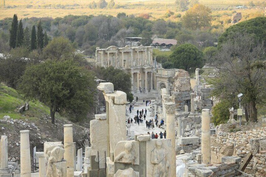 Ancient ruins with columns and a large building in the background. 5