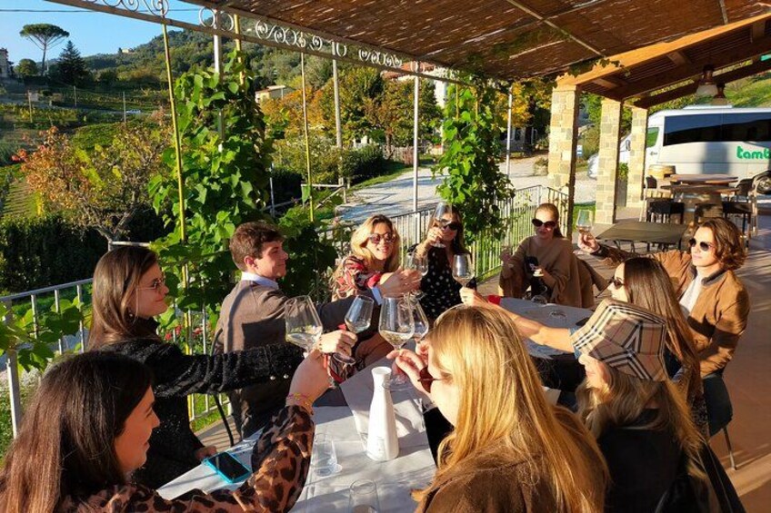 Un grupo de personas cenando al aire libre en un restaurante con vistas al campo. 1