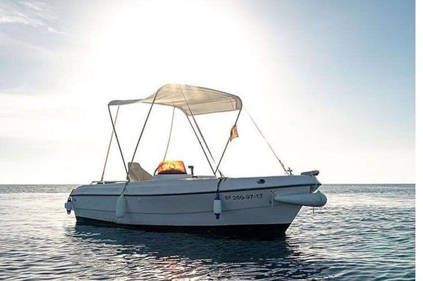 A small motorboat with a canopy, floating on calm water. 3