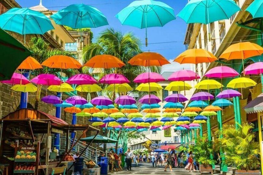 A street with colorful umbrellas hanging overhead. 2
