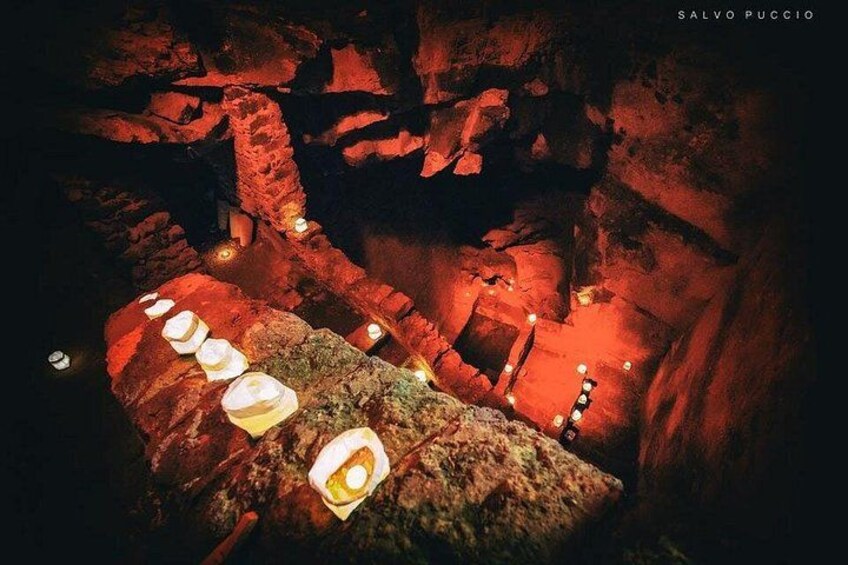 Una cueva con velas iluminadas sobre rocas. 3