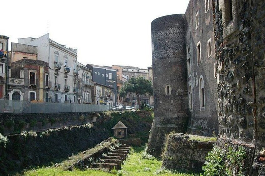 Un muro de piedra histórico, un edificio pequeño y un puente en un entorno urbano. 2