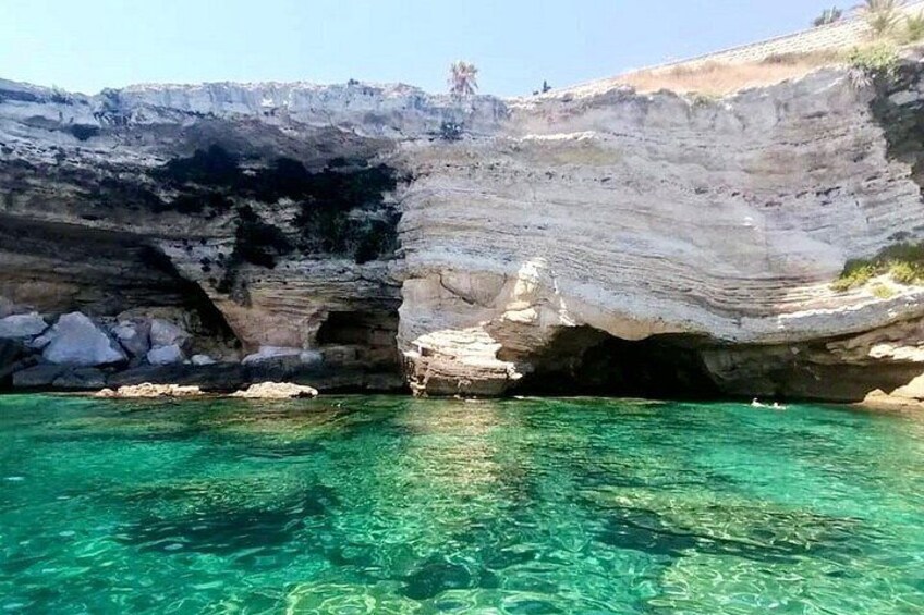 A coastal rock formation with clear turquoise water. 5