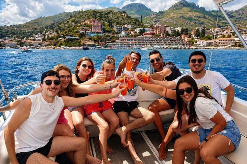 Un grupo de personas en un barco, con un pueblo costero al fondo. 1