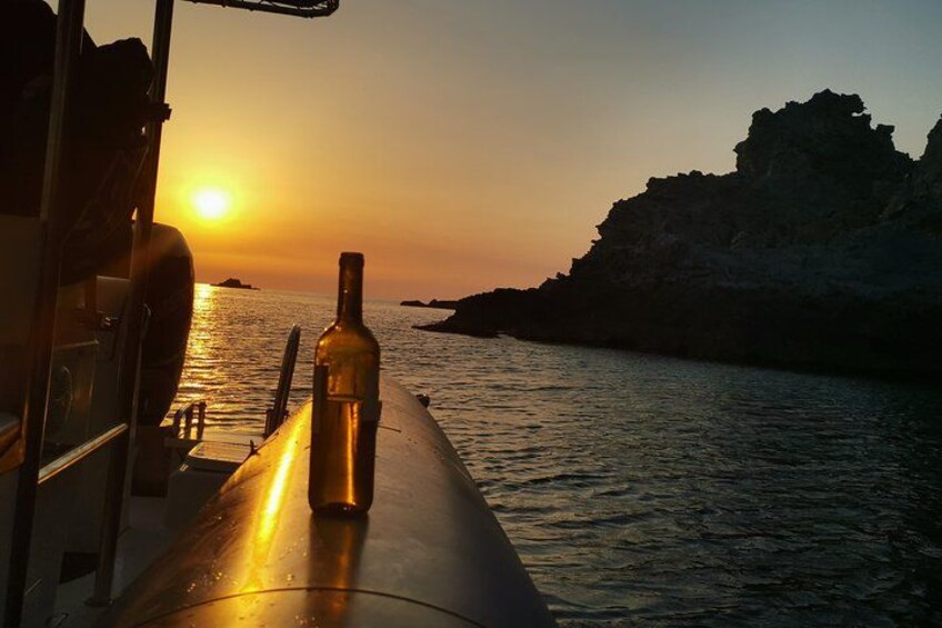 A sunset over water with a bottle on a boat. 5
