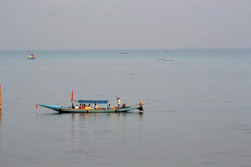 Ruhige See mit einem Boot voller Passagiere. 3
