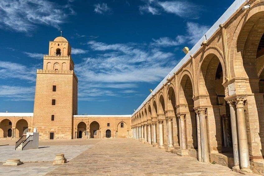 A historical building with a central tower and arched walkways. 3