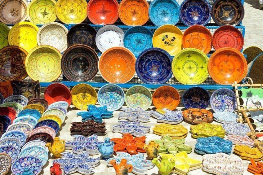 A variety of colorful ceramic bowls and plates displayed for sale. 5