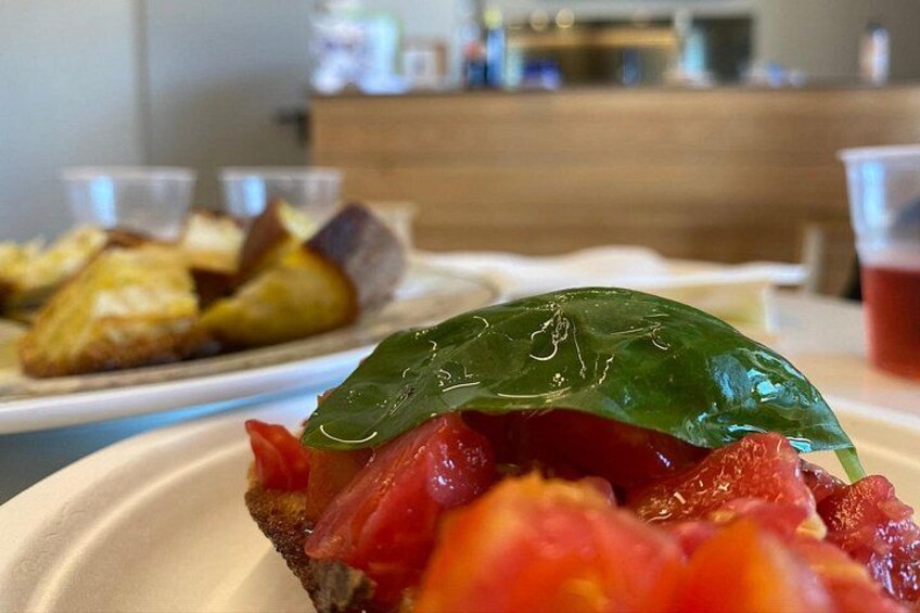 Ein Teller mit Essen und einem grünen Blatt darauf, im Hintergrund ein verschwommener Teller mit Gebäck. 4