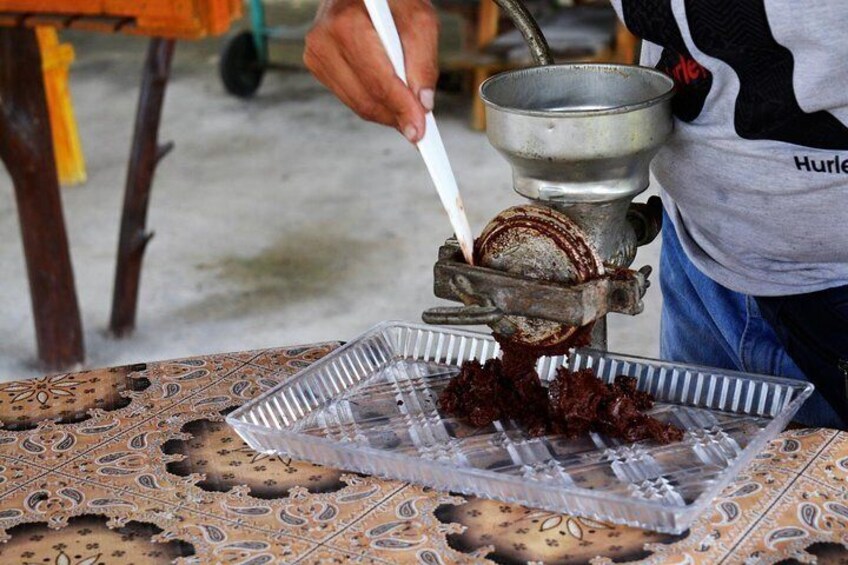 A person using a manual chocolate tempering machine to melt and cool chocolate. 3