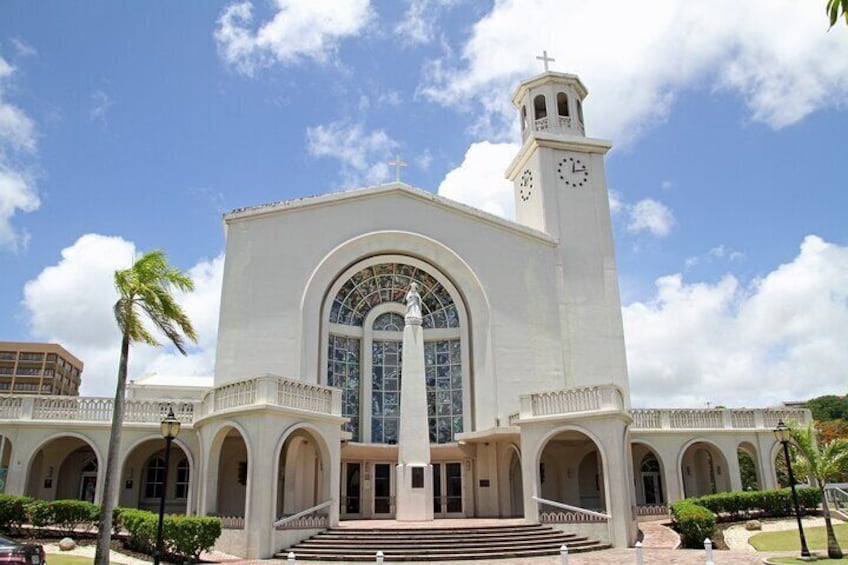 A large white church with a clock tower and arched windows. 5