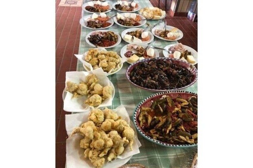 A table with various dishes, including fried items and a large bowl of salad. 3