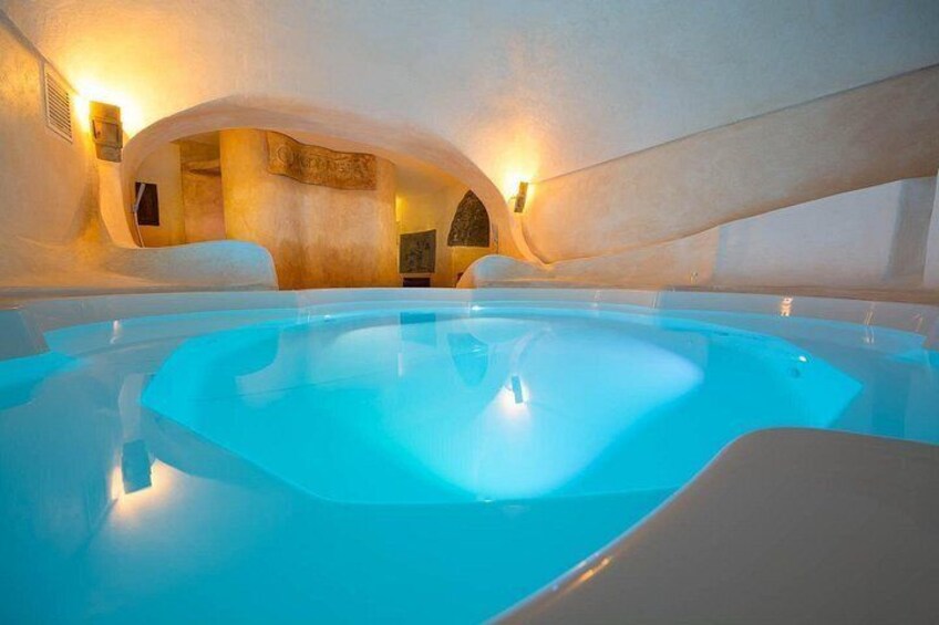 An indoor swimming pool with a unique arched ceiling and warm lighting. 1