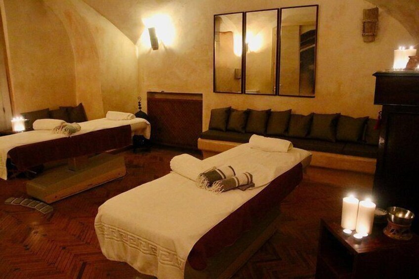 Una habitación con dos camas, un sofá y un espejo en la pared. 5