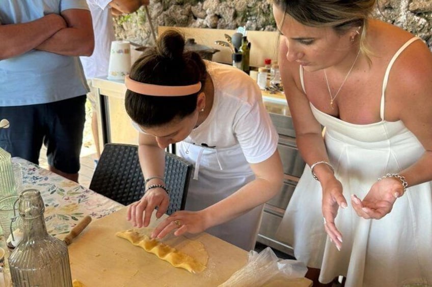 Deux femmes préparent des aliments à l’extérieur, près d’une table et d’ustensiles de cuisine. 5