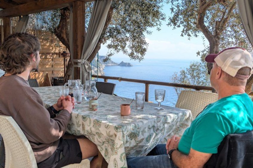 Deux personnes sont assises à une table, face à la mer. 1