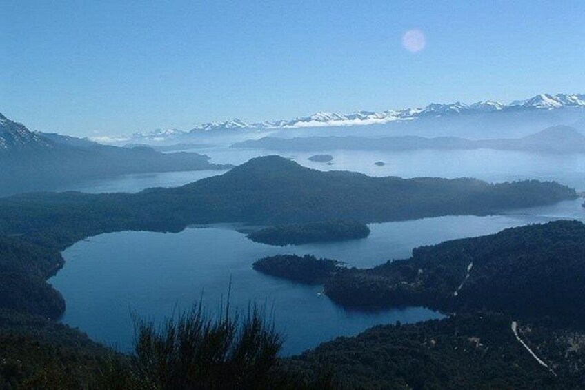Een meer, omringd door bergen, onder een heldere lucht. 2