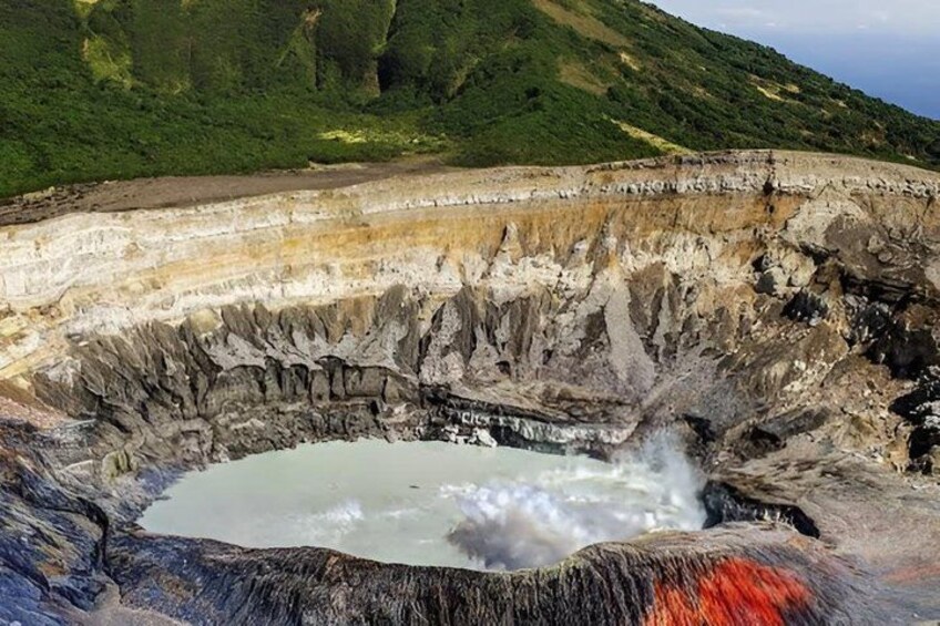 A geothermal crater with steam rising from the water. 2