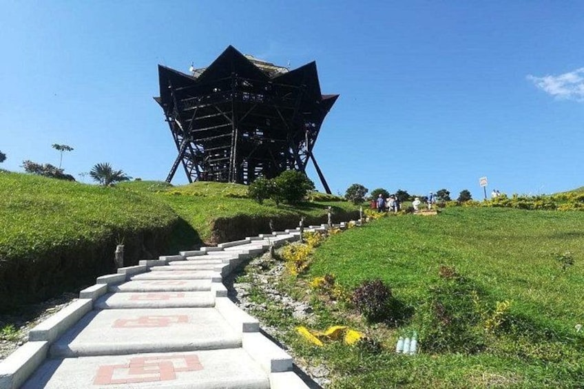 A unique architectural structure on a grassy hill with a concrete pathway leading up to it. 1