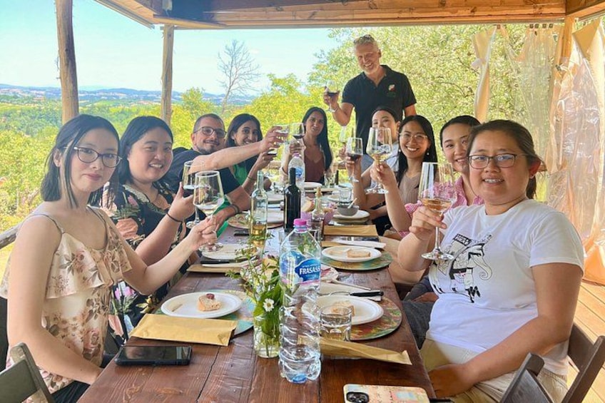 Un grupo de personas brindando alrededor de una mesa de madera con una vista panorámica al fondo. 5