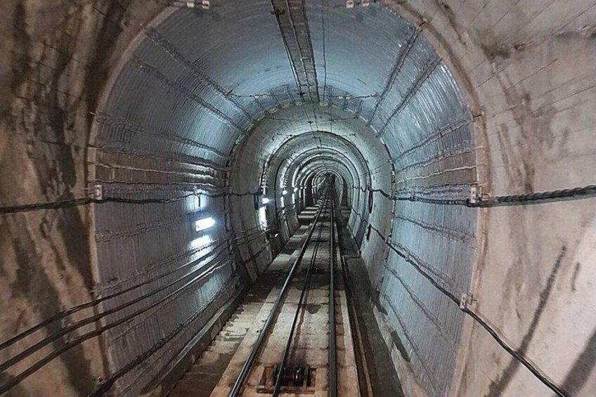 A tunnel with metal walls and a central walkway. 2
