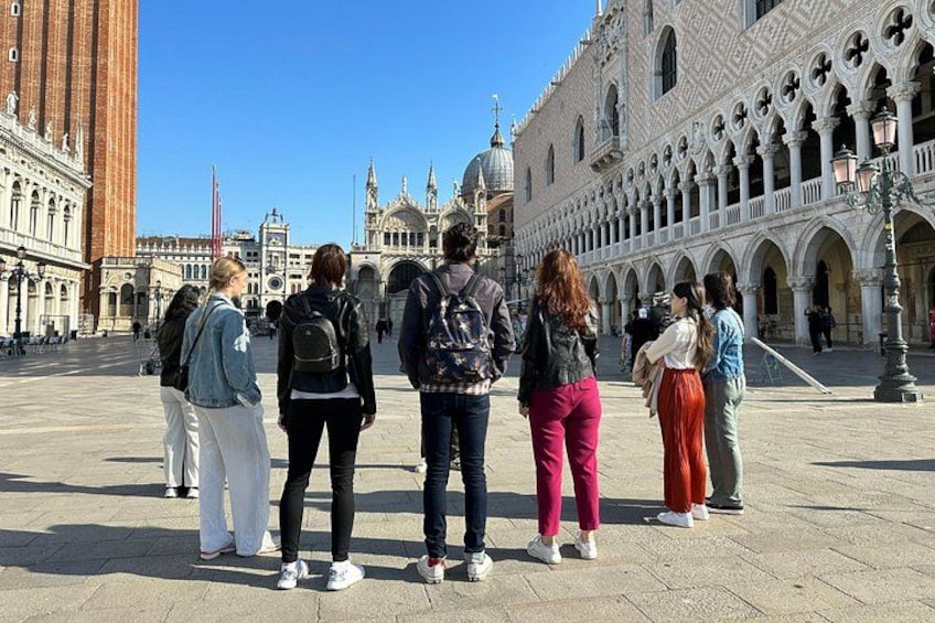 A group of people standing in a square with historic buildings in the background. 5