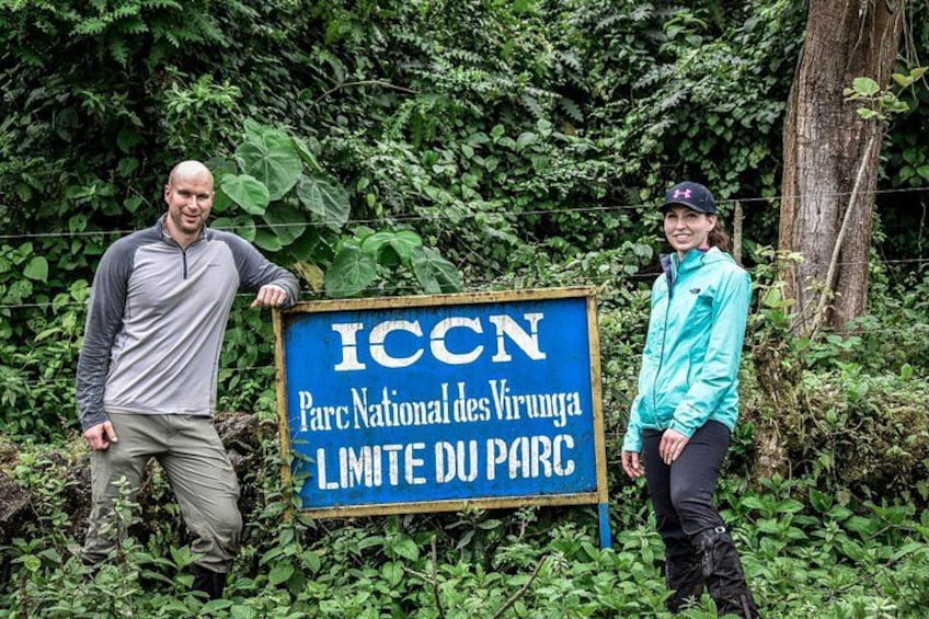 To personer står ved siden af et skilt, der viser 'ICCN Parc National des Virunga Limes du Parc'. 5