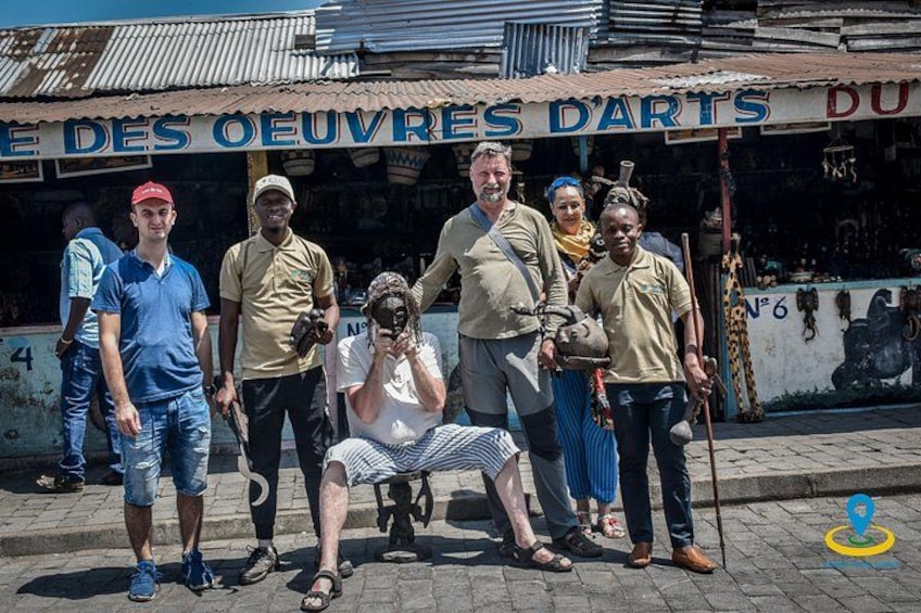 En gruppe mennesker poserer foran en butik med et skilt, der står 'OEUVRES D'ARTS'. 2