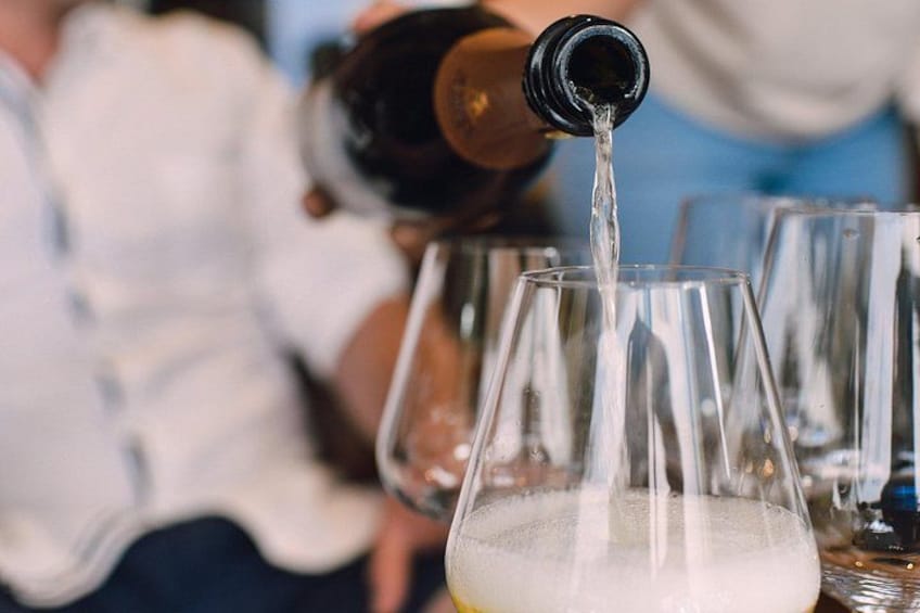 A person pouring a clear liquid into a glass. 2