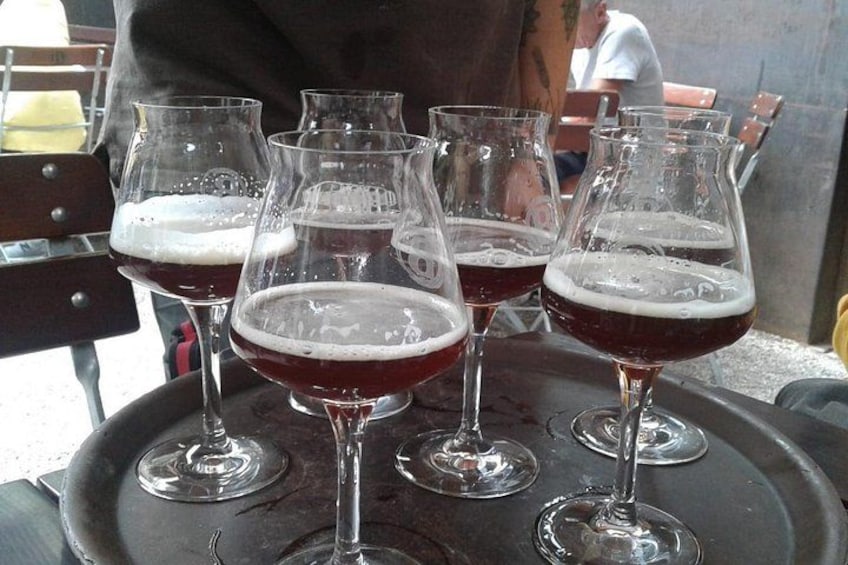 Four wine glasses filled with red wine on a tray. 2