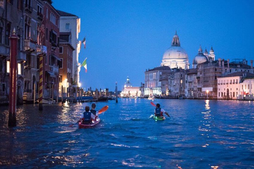 A canal with gondolas, historic buildings, and a prominent dome in the background. 5