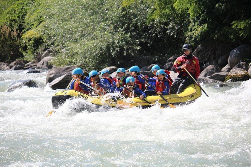 Un groupe de personnes à bord d’un radeau jaune navigue sur une rivière à courant rapide. 4