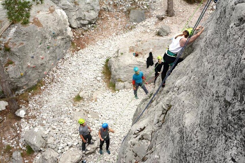 Un grupo de personas escalando una pendiente rocosa con un río en la base. 3