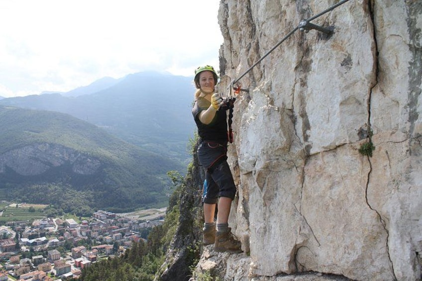 A person rock climbing on a cliff with a cityscape in the background. 1